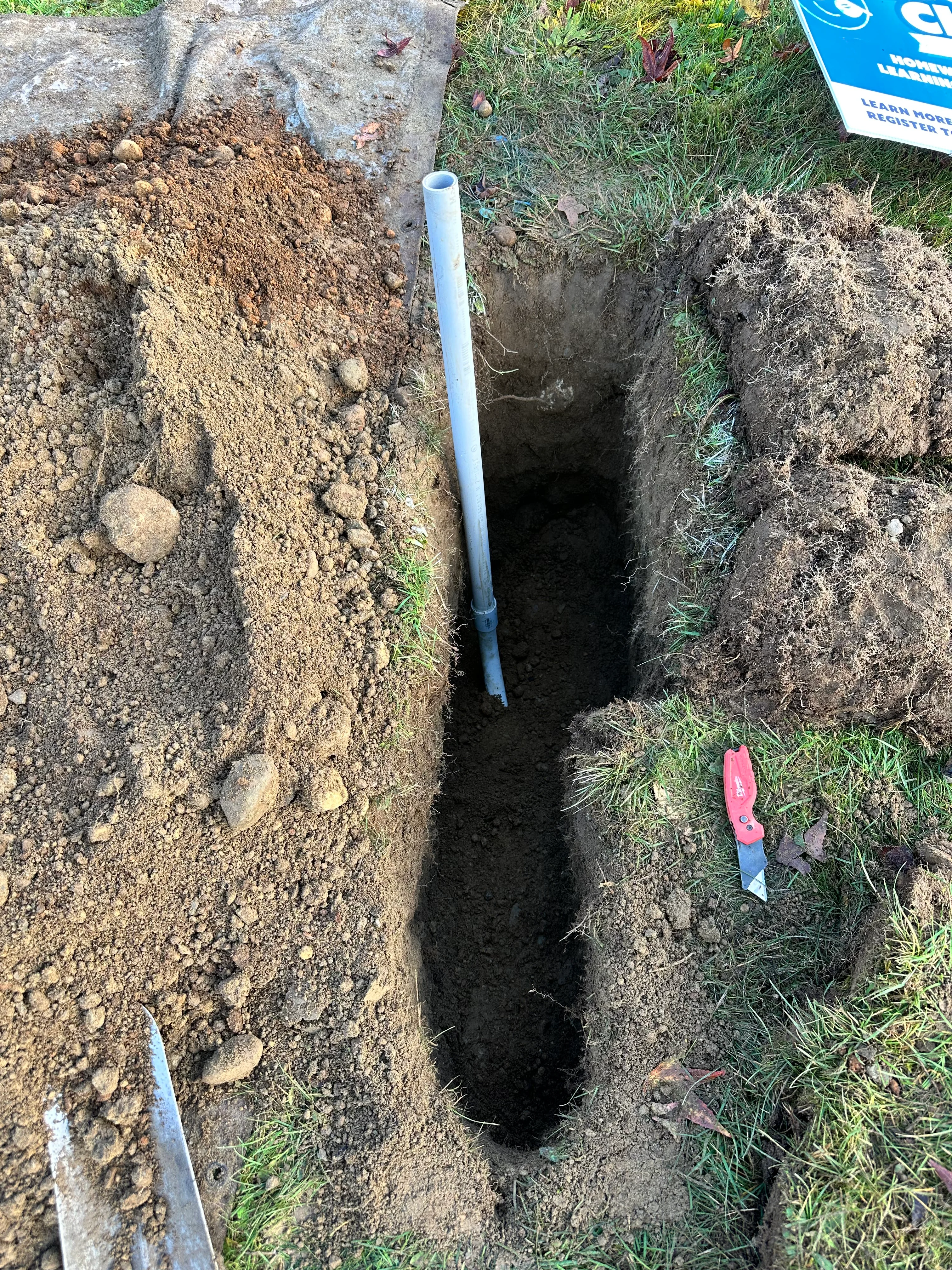 Deep excavation trench with PVC conduit for underground utility installation